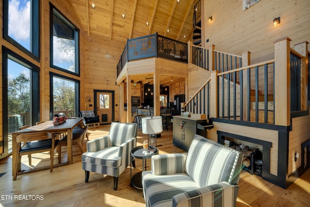 interior space with wood ceiling, high vaulted ceiling, beam ceiling, and light hardwood / wood-style flooring