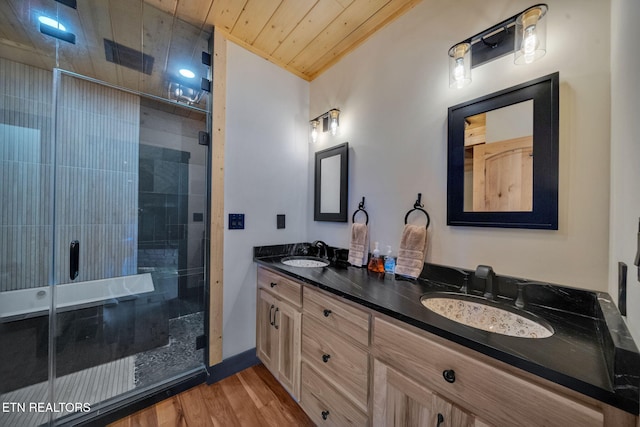 bathroom with wooden ceiling, hardwood / wood-style floors, a shower with shower door, and vanity