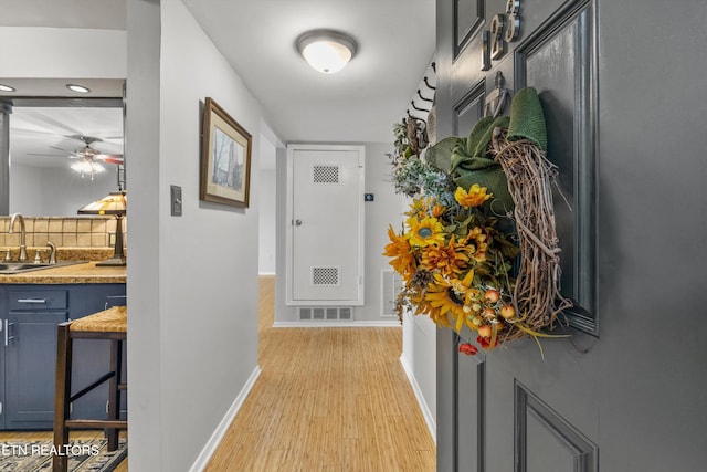 corridor featuring light hardwood / wood-style floors and sink