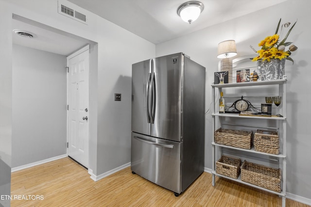 kitchen with stainless steel fridge and wood-type flooring