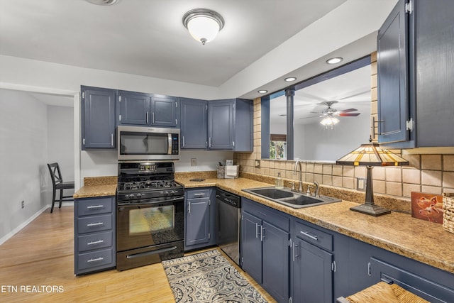 kitchen featuring stainless steel appliances, sink, blue cabinetry, light hardwood / wood-style floors, and ceiling fan