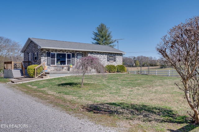 ranch-style home featuring a front yard and a wooden deck