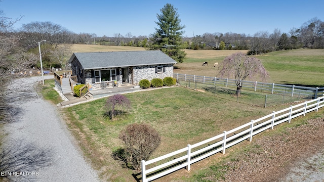 view of front of property with a front yard, a rural view, and covered porch