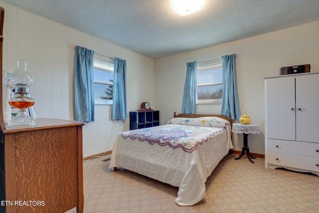 carpeted bedroom with wood walls and a textured ceiling