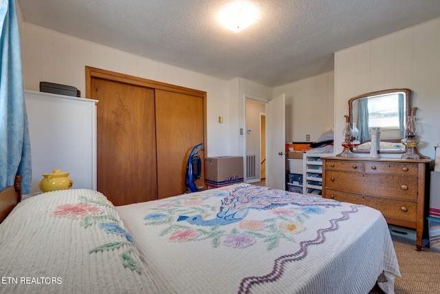 bedroom featuring carpet floors, a closet, and a textured ceiling