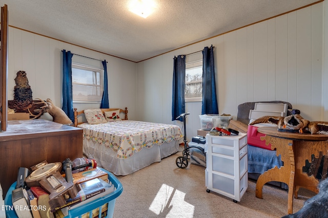 carpeted bedroom with wood walls and a textured ceiling