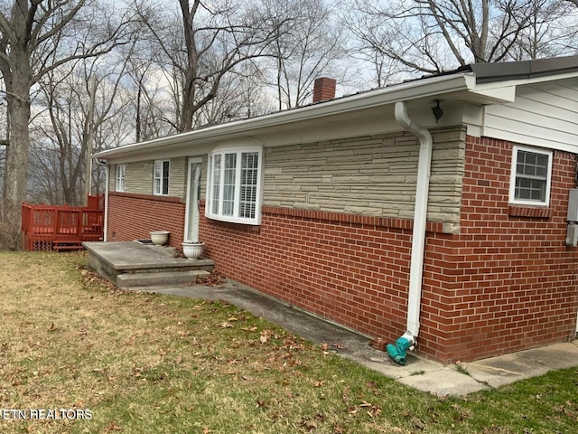 view of side of property featuring a deck and a yard