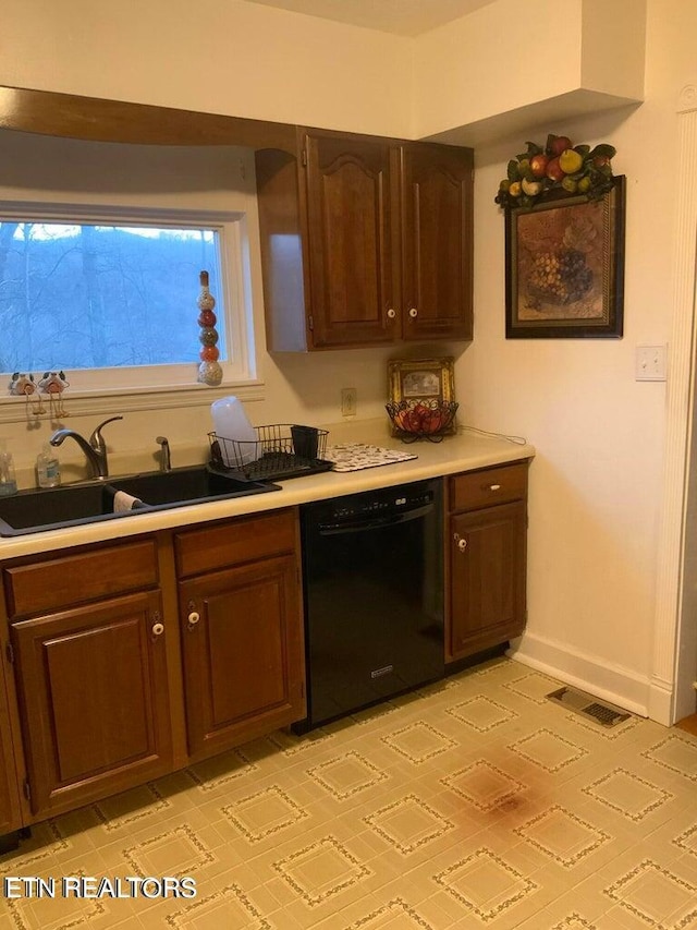 kitchen featuring dark brown cabinets, sink, and dishwasher