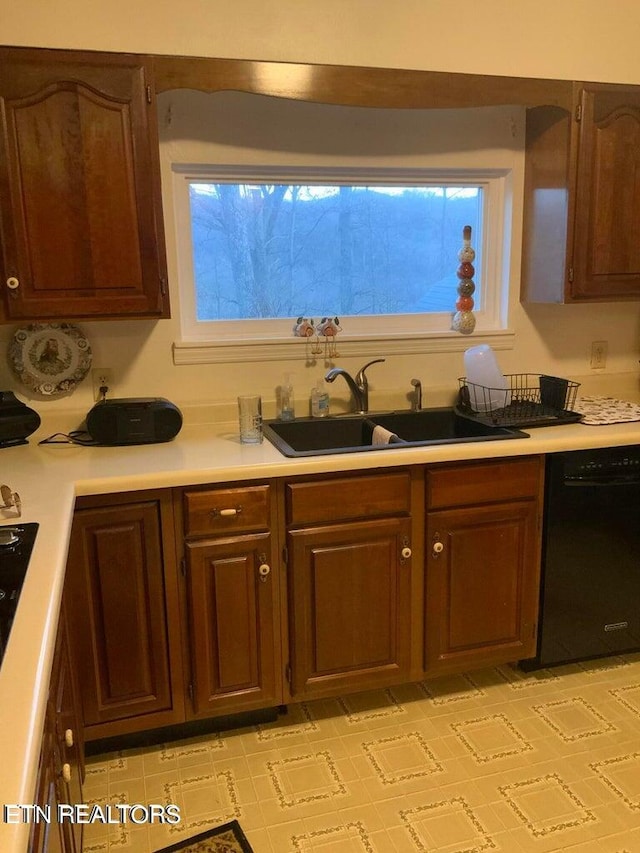 kitchen with a healthy amount of sunlight, black dishwasher, and sink