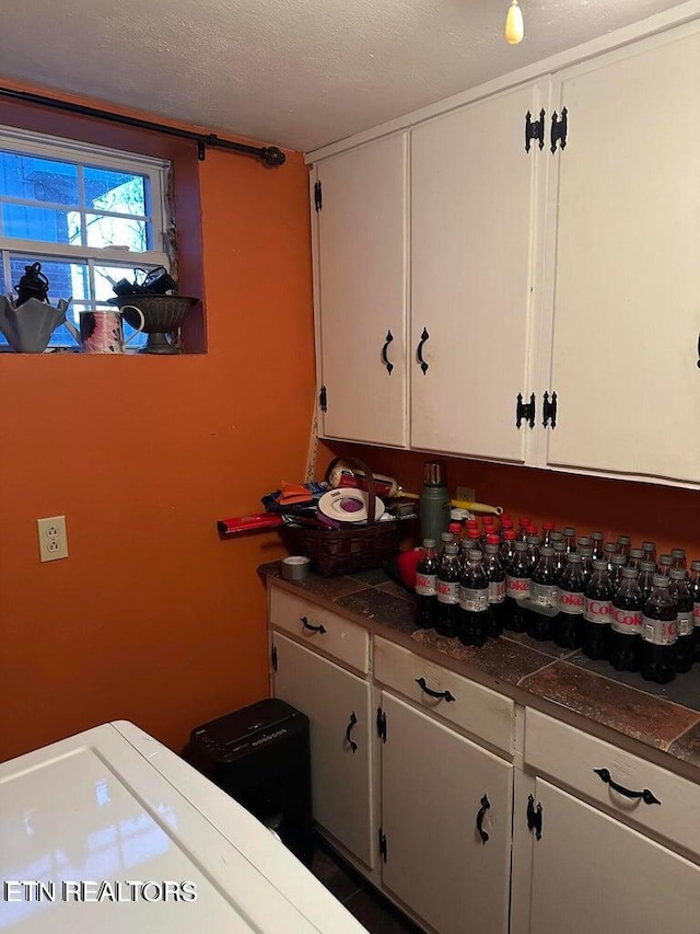 kitchen with white cabinets and a textured ceiling