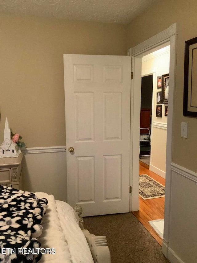 bedroom with a textured ceiling and dark wood-type flooring