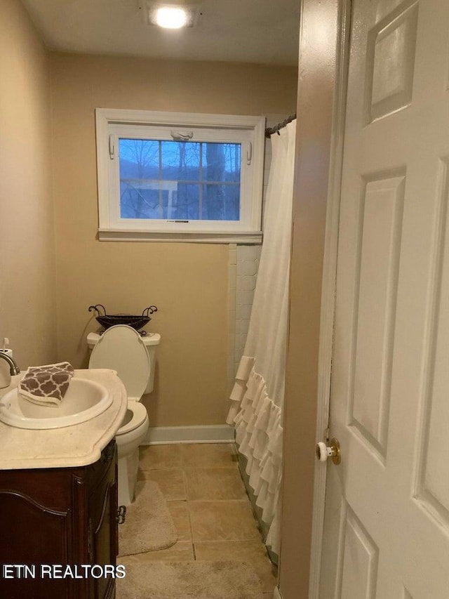 bathroom with tile patterned flooring, curtained shower, vanity, and toilet