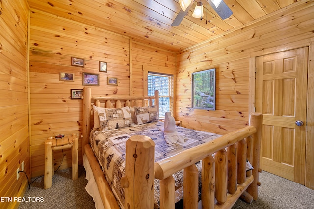 carpeted bedroom with wooden walls, ceiling fan, and wooden ceiling