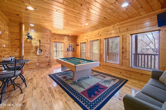 recreation room with wood walls, pool table, and light hardwood / wood-style floors