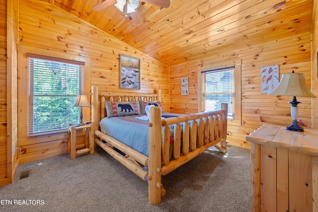 carpeted bedroom with ceiling fan, wooden walls, wood ceiling, and vaulted ceiling