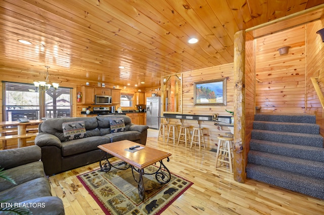 living room featuring light wood-type flooring, wooden walls, wooden ceiling, and an inviting chandelier