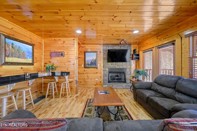 living room featuring wooden ceiling, light hardwood / wood-style flooring, and wooden walls