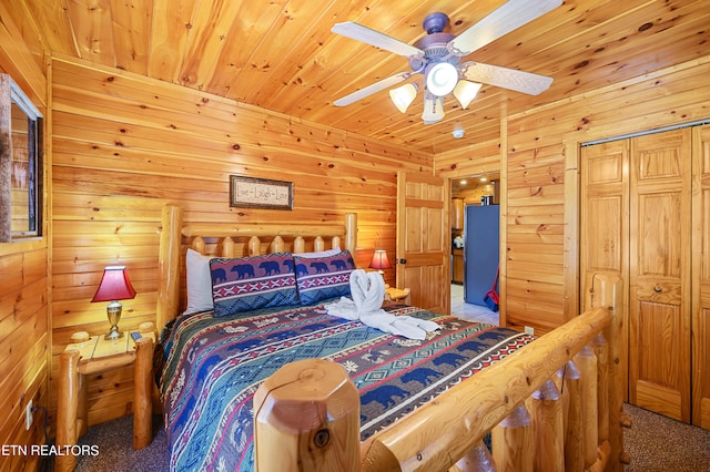 carpeted bedroom with wood walls, a closet, and ceiling fan