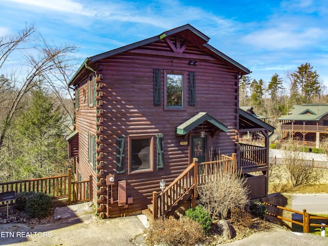 log cabin with a wooden deck