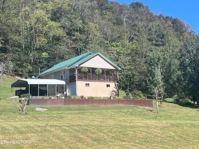 exterior space featuring a lawn, a sunroom, and a carport