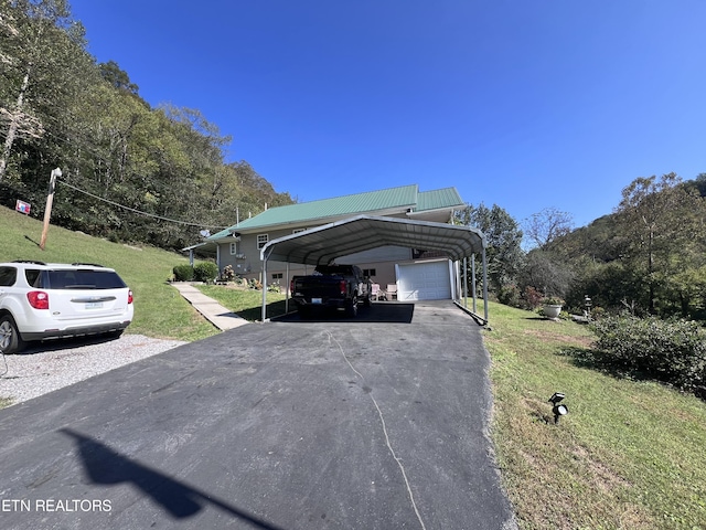 59 River Rd, Miracle, KY 40856 - view of side of home with a lawn, asphalt driveway, a metal roof, a detached carport, and a garage