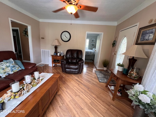 living room featuring a textured ceiling, light hardwood / wood-style floors, ceiling fan, and ornamental molding