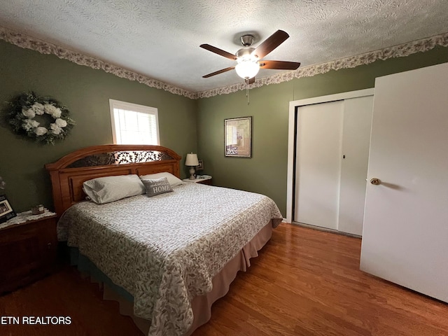 bedroom featuring a closet, ceiling fan, hardwood / wood-style floors, and a textured ceiling