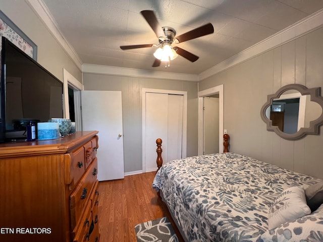 bedroom featuring light wood-type flooring, a closet, ceiling fan, and crown molding