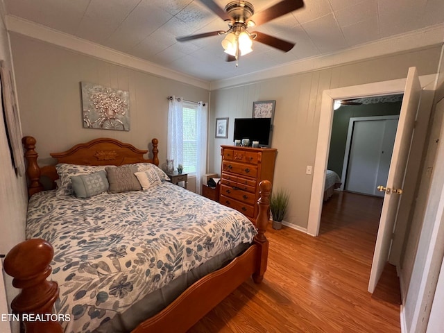 bedroom with light hardwood / wood-style floors, ceiling fan, and crown molding