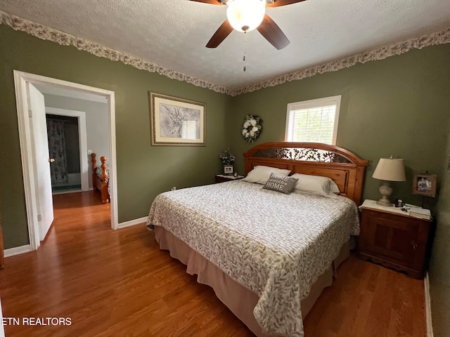 bedroom featuring ceiling fan, a textured ceiling, and hardwood / wood-style flooring