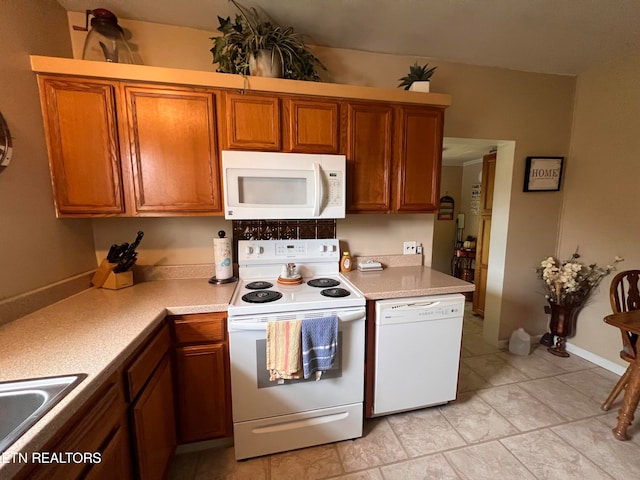 kitchen with sink, light tile patterned flooring, and white appliances