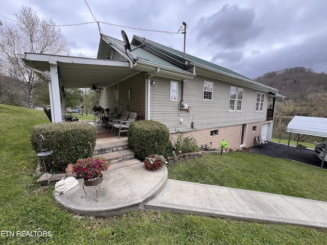 59 River Rd, Miracle, KY 40856 - back of property with a lawn, ceiling fan, and a garage