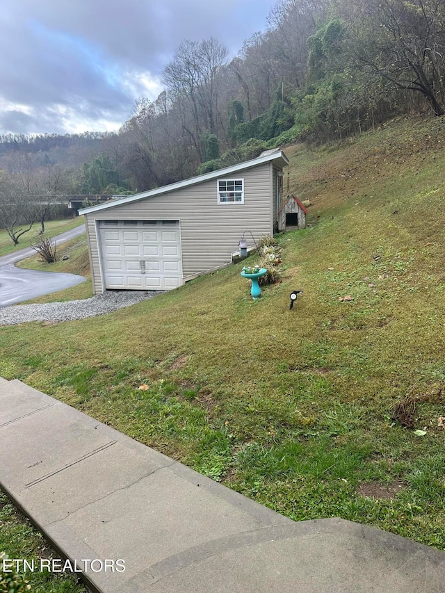 view of side of property with a lawn, an outbuilding, and a garage