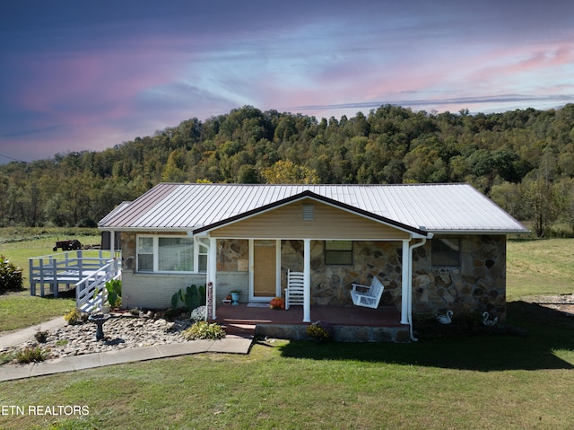 view of front of home featuring covered porch and a lawn