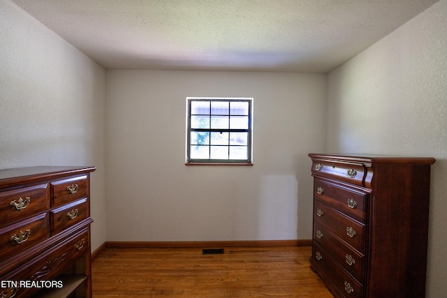 bedroom featuring a textured ceiling and light wood-type flooring