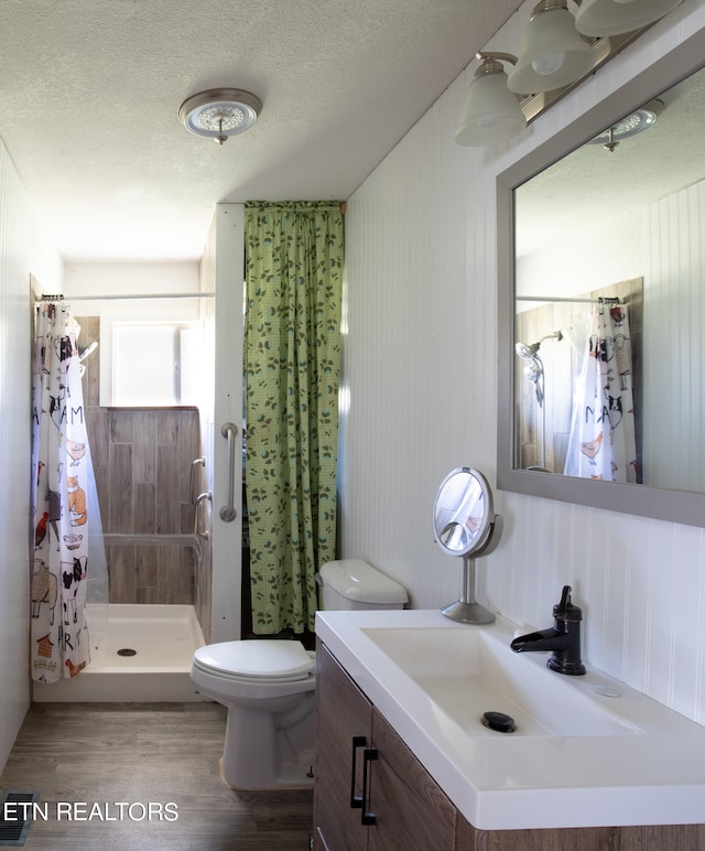 bathroom featuring curtained shower, a textured ceiling, toilet, vanity, and hardwood / wood-style flooring