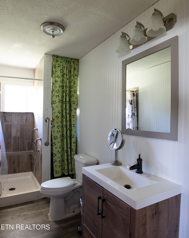 bathroom with curtained shower, a textured ceiling, toilet, vanity, and hardwood / wood-style flooring