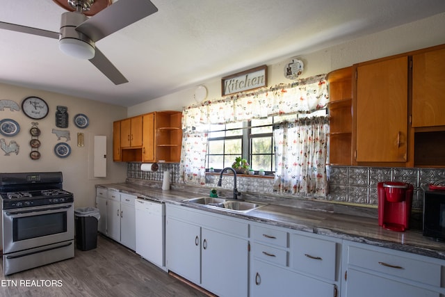 kitchen with stainless steel gas range oven, white dishwasher, sink, and white cabinets