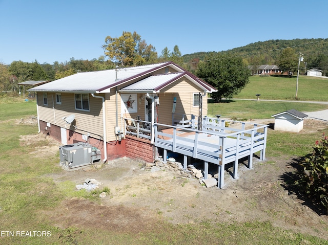 back of property featuring central AC and a lawn