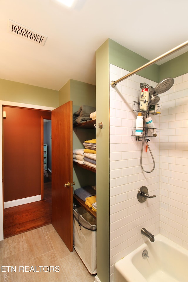 bathroom featuring hardwood / wood-style flooring and tiled shower / bath combo