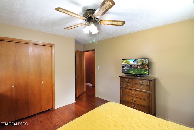 bedroom featuring a closet, dark hardwood / wood-style floors, a textured ceiling, and ceiling fan