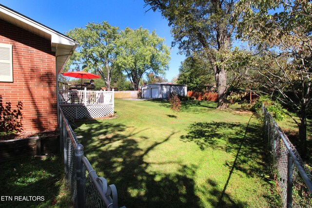 view of yard featuring a deck and a storage unit