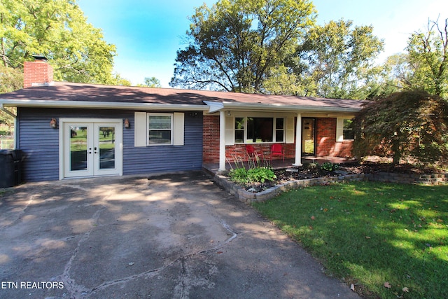 single story home featuring a porch and a front lawn