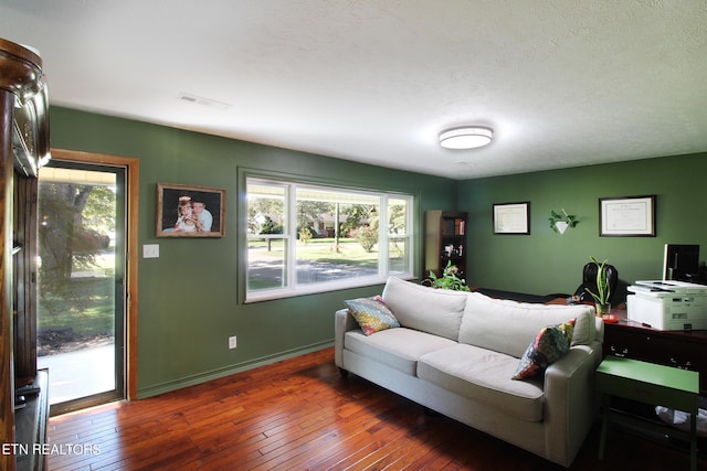 living room featuring dark wood-type flooring and a textured ceiling