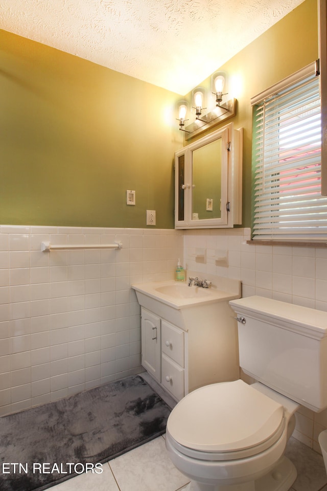 bathroom with vanity, tile walls, toilet, and tile patterned floors