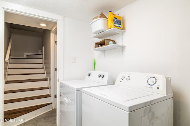 laundry area featuring a textured ceiling, washer and clothes dryer, and tile patterned flooring