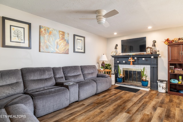 living room with a textured ceiling, dark hardwood / wood-style floors, and ceiling fan