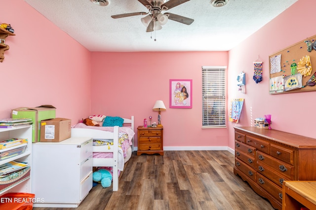 bedroom with ceiling fan, a textured ceiling, and dark hardwood / wood-style floors