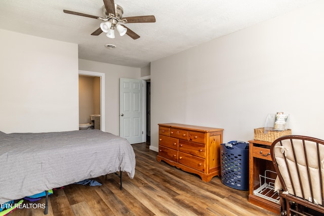 bedroom with a textured ceiling, hardwood / wood-style flooring, and ceiling fan