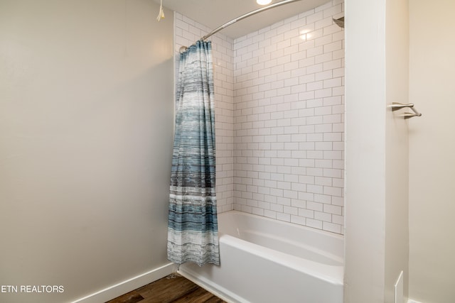 bathroom with shower / tub combo with curtain and hardwood / wood-style floors